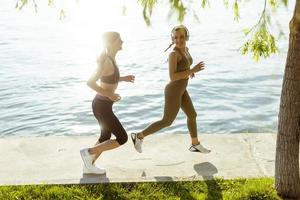 Mujer joven haciendo ejercicio para correr por el paseo fluvial foto