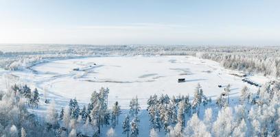 Aerial view of snow covered forest around beautiful lake