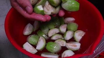 la main du chef a tenu l'aubergine verte de l'eau utilisée pour faire tremper l'aubergine verte et l'a doucement relâchée dans l'eau au ralenti video