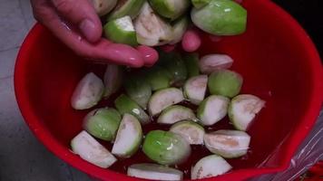 Die Hand des Küchenchefs hielt die grüne Aubergine aus dem Wasser, das zum Einweichen der grünen Aubergine verwendet wurde, und ließ sie sanft in Zeitlupe ins Wasser fallen video