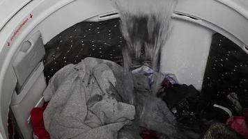 deje que el agua fluya hacia la lavadora que tiene ropa esperando para ser lavada. lavadora de carga superior video