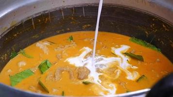 verser le lait de coco blanc dans la casserole de curry vert. video