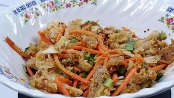 Close Up Thai street food Spicy fried chicken salad with carrots and vegetables, white background video