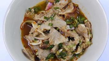 cierre la comida callejera tailandesa, ensalada picante de cerdo a la parrilla. video