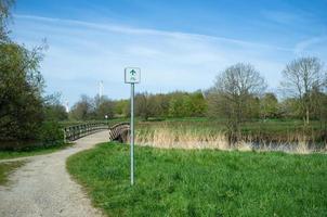 señal de tráfico con una ruta para ciclistas en medio de un parque foto