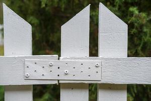 valla de madera pintada de blanco, en el patio, que prohíbe el acceso al territorio privado. foto