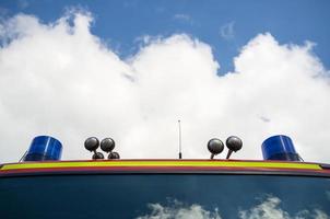 Fire engine with signal lamps and a siren, against the blue sky and white clouds. Rescue and safety concept. Copy space. photo