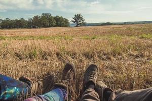 Close up people sitting on dry grass in field concept photo