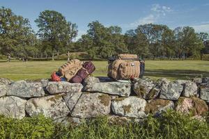 Hiker backpacks on limestone fence landscape photo