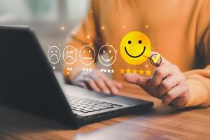 Man hand using computer laptop with popup five star icon for feedback review satisfaction service, testimonial. Customer service experience and business satisfaction survey. photo