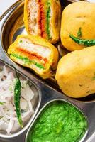 ulta vada pav se hace con un bollo relleno de patata picante, llamado pav inside vada, inside out vada pav foto