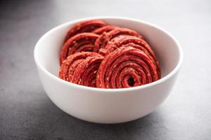 Beatroot chakli, murukku, Beetroot chakli, a spiral fried snack from India made in Diwali festival photo