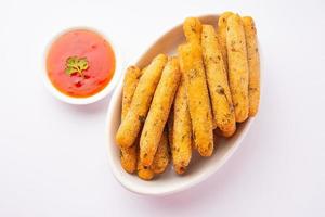 crispy Rava Aloo fingers or Potato semolina fried finger sticks served with ketchup photo