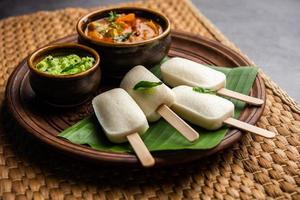 Idly lollipop or idli candy with stick served with sambar and chutney,South indian breakfast photo