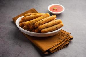 crispy Rava Aloo fingers or Potato semolina fried finger sticks served with ketchup