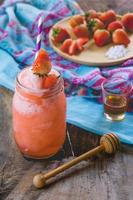 jugo de batido de fresa, sobre miel sabrosa para el verano en la mesa de madera, jugo de agua dulce para la salud