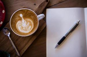 Top view coffee latte aroma cup and tasty christmas cake relaxtime waiting for idea on paper note on wood table in cafe coffee shoop photo