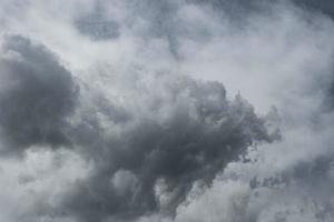 Dark cloud against the background of white clouds. photo