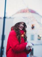 mujer en ropa de invierno con luces de bengala foto