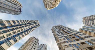 circular motion and view up from ground to blue sky among skyscrapers, look at house from bottom up video