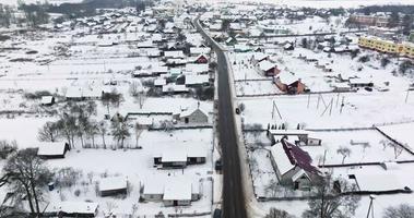 antenn panorama- vinter- se av by med hus, lador och grus väg med snöfall video