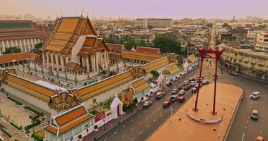 une vue aérienne de la balançoire géante rouge et du temple suthat thepwararam au coucher du soleil, l'attraction touristique la plus célèbre de bangkok, thaïlande video