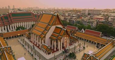 eine luftaufnahme der roten riesenschaukel und des suthat thepwararam tempels bei sonnenuntergang, der berühmtesten touristenattraktion in bangkok, thailand video