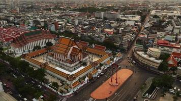 zeitraffer 4k einer luftaufnahme der roten riesenschaukel und des suthat thepwararam tempels bei sonnenuntergang, der berühmtesten touristenattraktion in bangkok, thailand video