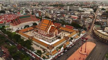 zeitraffer von tag zu nacht einer luftaufnahme der roten riesenschaukel und des suthat thepwararam tempels, der berühmtesten touristenattraktion in bangkok, thailand video