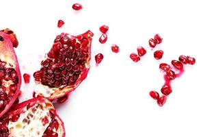 Closeup of fresh red pomegranate on white background photo