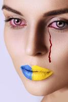 Crying Ukrainian woman with a bloody tears photo