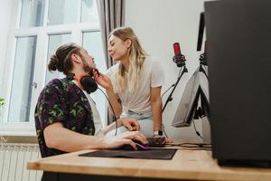 pareja joven relajándose y mostrando amor mientras juega videojuegos en una computadora personal foto