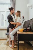 pareja feliz en la mesa con computadora personal de juego en casa foto