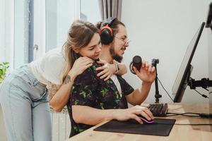blogger de tipo y su hermosa novia en el escritorio con computadora personal foto