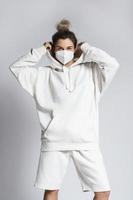 Young woman wearing white hoodie and ffp2 respirator mask photo