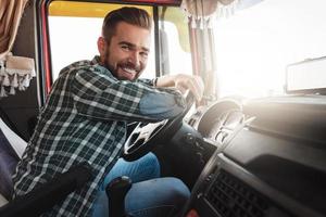 Young and happy smiling truck driver inside his vehicle photo