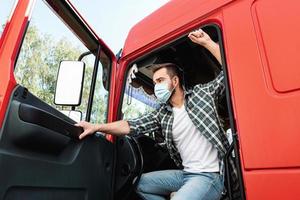 Young truck driver wearing protective mask photo