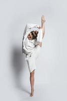Woman dancer wearing white clothes is performing against on background photo
