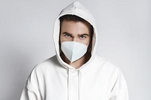 Young man wearing white hoodie and ffp2 respirator mask photo