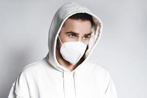 Young man wearing white hoodie and ffp2 respirator mask photo