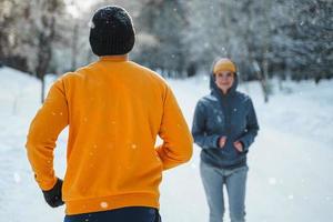 Sportive couple during winter jogging in city park photo