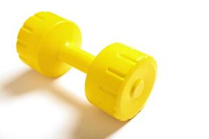 Yellow dumbbell with shadow on white background photo