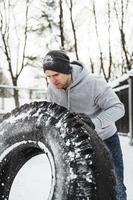deportista fuerte durante su entrenamiento de entrenamiento cruzado durante el día de invierno nevado y frío. foto