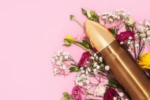 Pacifism and non-violence movement. Bullet and bunch of different flowers against pastel pink background.