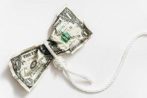 White rope tangled around a crumpled one dollar bill. photo