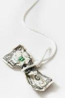 White rope tangled around a crumpled one dollar bill. photo