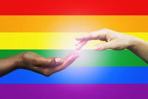 Female hands of diverse races against LGBT community flag photo