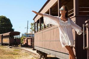 Young woman on the old train carriage photo