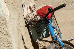 Old postman bicycle parked against a wall photo