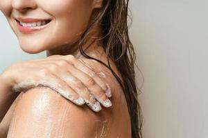 Sensual woman washing her body with shower gel photo